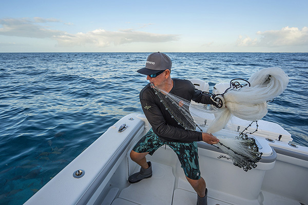 Captain Steve Rodger, co-host of Into the Blue casts a net from his fishing charter in the Florida Keys.
