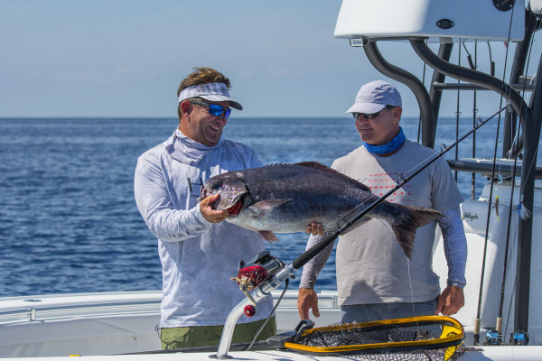 Captains Rowland and Tudor hold up their Florida Keys catch while on their fishing charter.