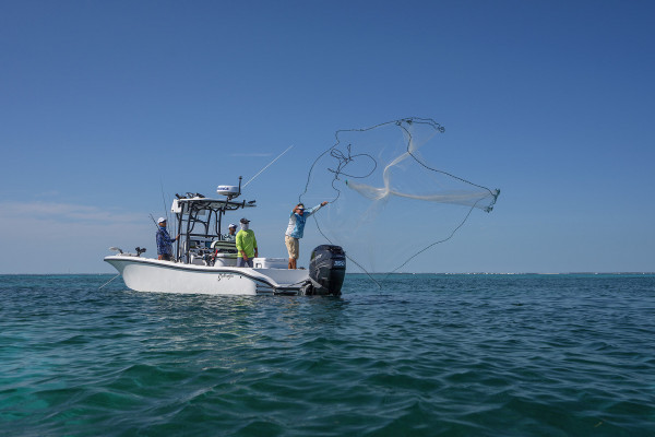 The Saltwater Experience crew casts a net from their fishing charter in the Florida Keys.