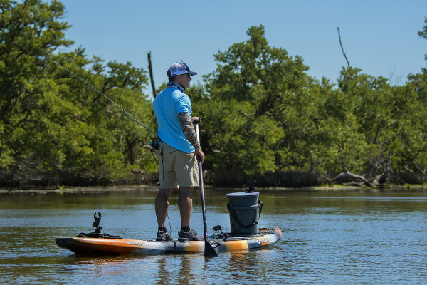 An angler fishes from his stand up paddleboard inshore.