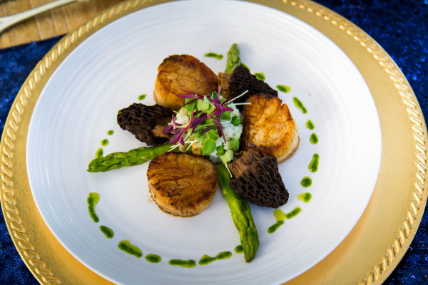 Event catering at Hawks Cay Resort featuring a plate of scallops, asparagus and more.